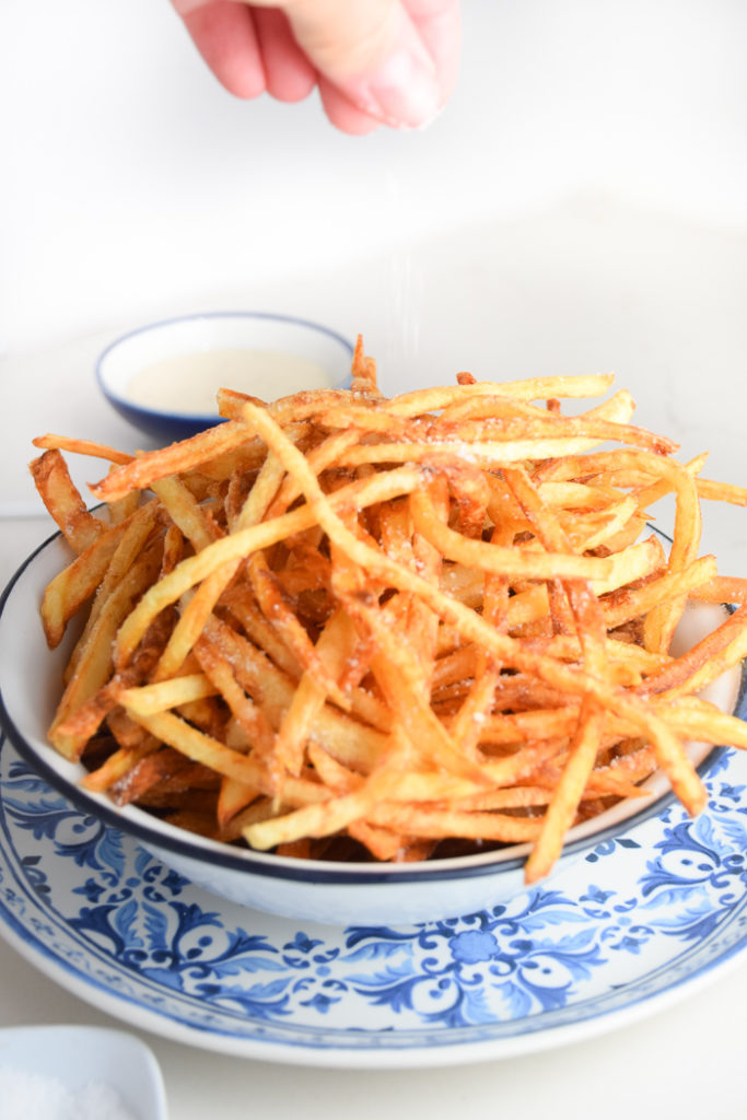 Bowl of french fries on a white and blue plate