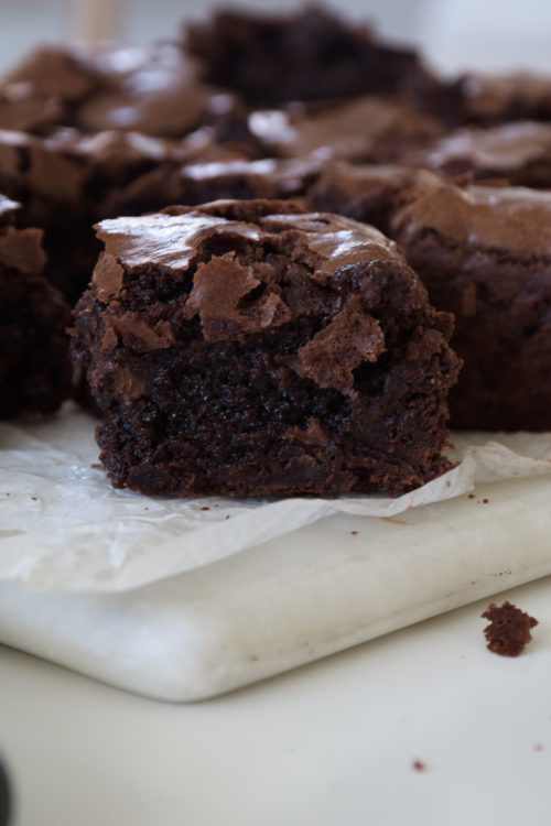 Brownies with crinkle tops on parchment paper